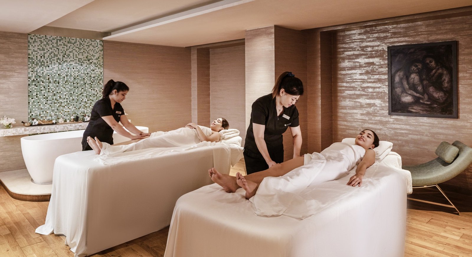 Spa therapists providing relaxing treatments in a wellness treatment room.
